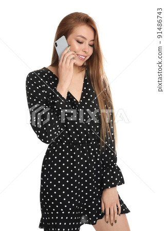 Teenage girl talking on smartphone against white background Teenage girl talking on smartphone against white background 91486743