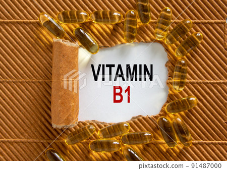 The text 'vitamin B1' appearing behind torn brown paper. Yellow pills. Concept. Beautiful background. The text 'vitamin B1' appearing behind torn brown paper. Yellow pills. Concept. Beautiful background. 91487000