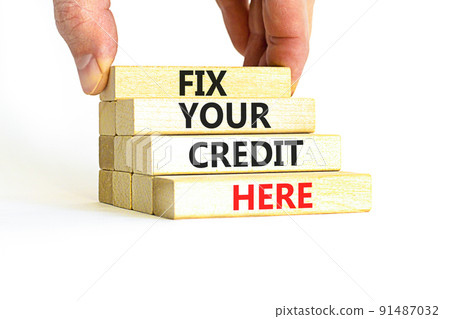 Fix your credit here symbol. Concept words Fix your credit here on wooden blocks on a beautiful white table white background. Businessman hand. Business, finacial and fix your credit here concept. 91487032