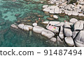 Lake Tahoe rocky shoreline. Ladies relaxing in the crystal clear water 91487494