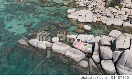 Lake Tahoe rocky shoreline. Ladies relaxing in the crystal clear water Lake Tahoe rocky shoreline. Ladies relaxing in the crystal clear water 91487500