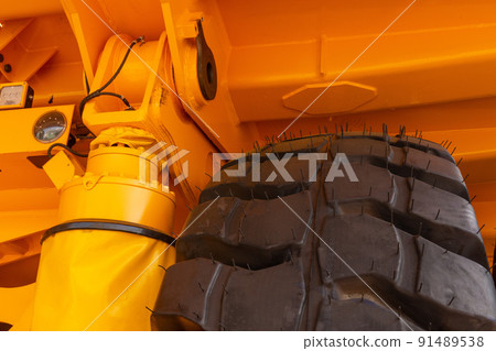 Huge rear wheels of dump truck at unusual angle closeup. Huge rear wheels of dump truck at unusual angle closeup. 91489538