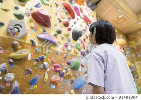 Elementary school girl confirming assignments by bouldering Elementary school girl confirming assignments by bouldering 91491904