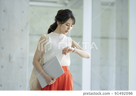 Business woman looking at a smart watch Business woman looking at a smart watch 91492096