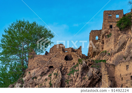 ruins of walls of houses on a cliff in the abandoned village of Gamsutl 91492224