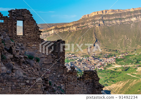 walls of abandoned houses on a mountain cliff in the ghost village of Gamsutl in Dagestan, on the opposite side of the valley the inhabited village of Chokh is visible walls of abandoned houses on a mountain cliff in the ghost village of Gamsutl in Dagestan, on the opposite side of the valley the inhabited village of Chokh is visible 91492234