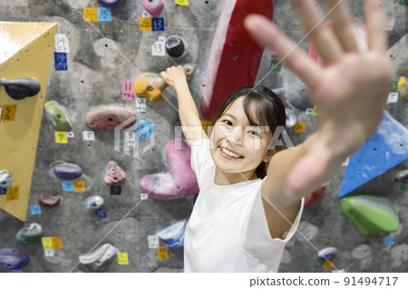 Young woman bouldering Young woman bouldering 91494717