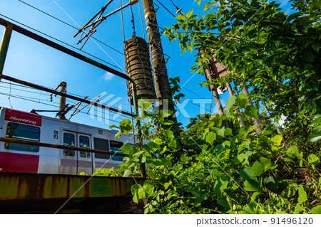 Train and blue sky passing through an old railway bridge on the JR Sanyo Main Line 91496120