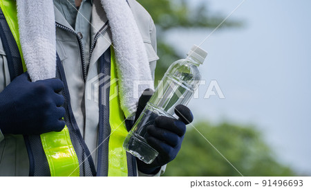 Men in work clothes with water from PET bottles | Image of measures against heat stroke in the construction industry 91496693