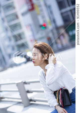 Woman sitting on the roadside Woman sitting on the roadside 91499352