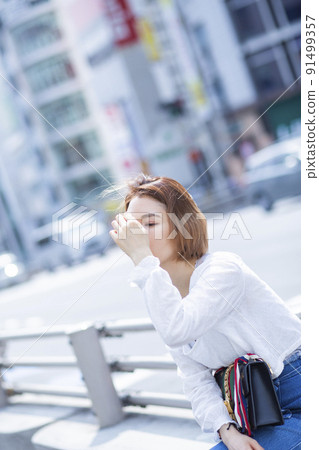 Woman sitting on the roadside Woman sitting on the roadside 91499357