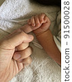 A baby who squeezes his mother's fingers while sleeping 91500028
