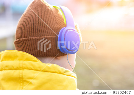 The boy listens to music. Blue headphones on the head. 91502467