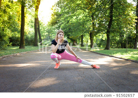 Young sexy girl doing stretching. Fitness woman training in the park 91502657