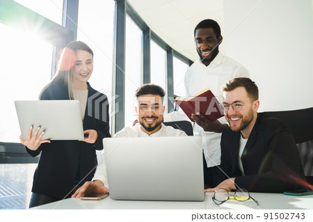 Group of multiracial office workers laughing while looking at laptop. .Employees of the company are working on a new project. Group of multiracial office workers laughing while looking at laptop. .Employees of the company are working on a new project. 91502743