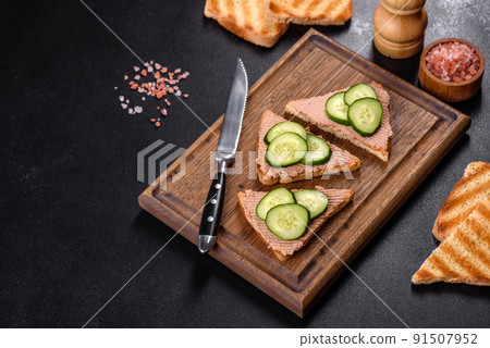 Delicious fresh sandwich with chicken liver pate with crispy toast, butter and cucumber 91507952