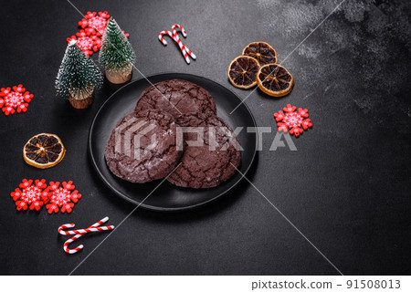 Delicious fresh chocolate biscuits on a dark concrete background with Christmas toys 91508013