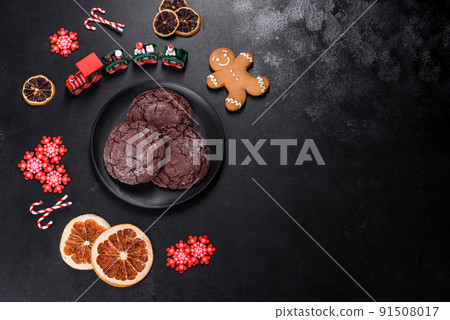 Delicious fresh chocolate biscuits on a dark concrete background with Christmas toys 91508017