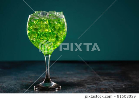 Green cocktail in a glass full of ice on the table Green cocktail in a glass full of ice on the table 91508059