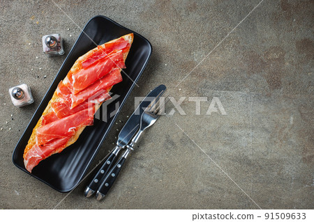 Traditional Spanish breakfast. Tostada with different toppings on a dark background. Top view with copy space 91509633