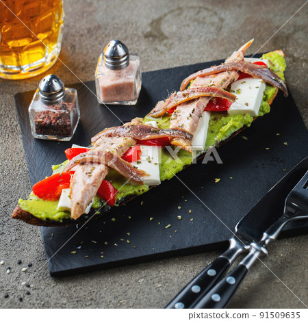 Traditional Spanish breakfast. Tostada with different toppings on a dark background 91509635