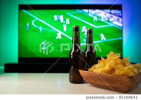 Beer and snacks set on football match tv background Beer and snacks set on football match tv background 91509641