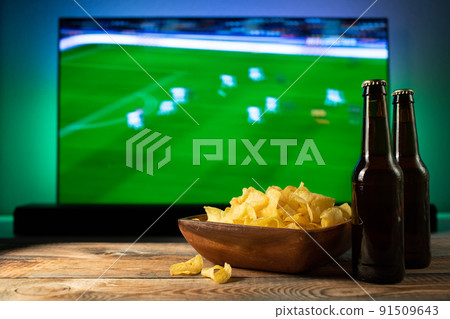Beer and snacks set on football match tv background Beer and snacks set on football match tv background 91509643