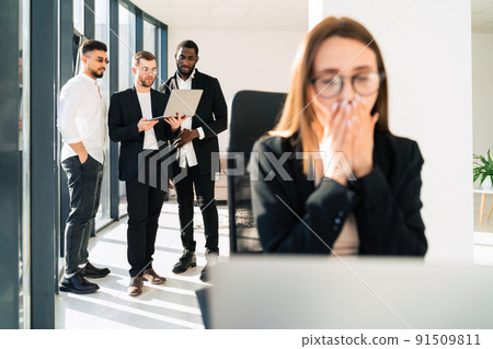 Surprised woman sitting at laptop in office Surprised woman sitting at laptop in office 91509811