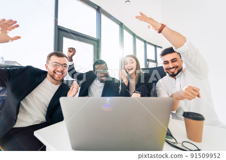 Office workers rejoice of victory while sitting at laptop Office workers rejoice of victory while sitting at laptop 91509952