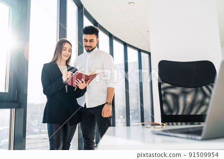 The secretary shows the schedule of business meetings to her boss The secretary shows the schedule of business meetings to her boss 91509954