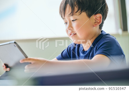 小學生在平板電腦上在線學習 小學生在平板電腦上在線學習 91510347