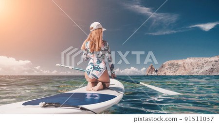Healthy happy fit woman in bikini relaxing on a sup surfboard, floating on the clear turquoise sea water. Recreational Sports. Stand Up Paddle boarding. Summer fun, holidays travel. Active lifestyle Healthy happy fit woman in bikini relaxing on a sup surfboard, floating on the clear turquoise sea water. Recreational Sports. Stand Up Paddle boarding. Summer fun, holidays travel. Active lifestyle 91511037