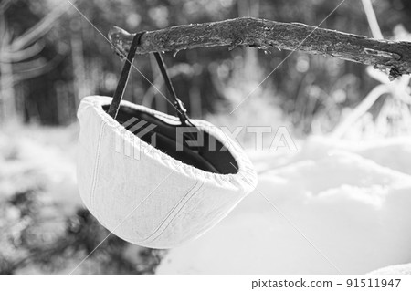 German Wehrmacht Infantry Soldiers White Helmet hanging on wooden banch in snow winter forest. World War II old army equipment ammunition. Metal Helmet Of German Infantry Wehrmacht Soldier At World 91511947