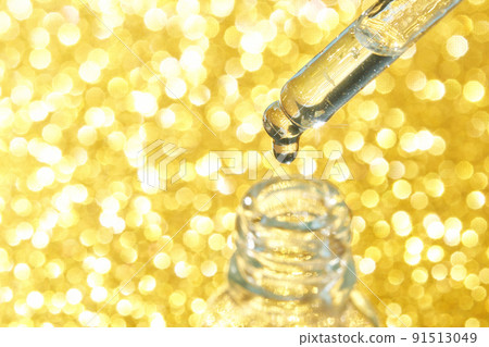 Serum gel texture swatch. Transparent drop with golden sparkles with bubbles 91513049