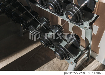 Dumbbells on metal racks in the gym. Dumbbells on metal racks in the gym. 91513066