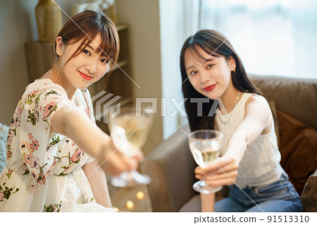 Two women chatting with a glass in their hands 91513310