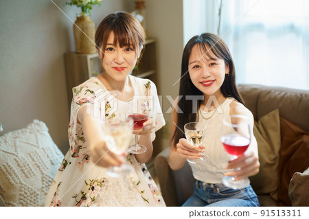 Two women chatting with a glass in their hands 91513311