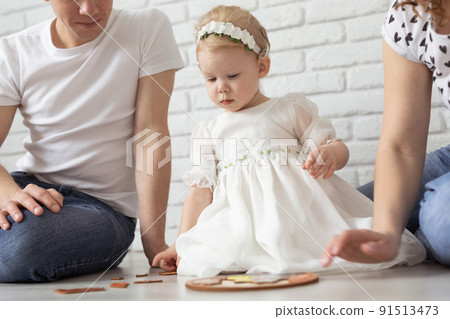 Baby child with hearing aids and cochlear implants plays with parents on floor. Deaf and rehabilitation and diversity concept Baby child with hearing aids and cochlear implants plays with parents on floor. Deaf and rehabilitation and diversity concept 91513473