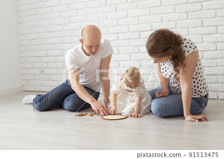 Child girl with cochlear implant plays at home with mother and father. Hear impairment and diversity and hearing aid 91513475