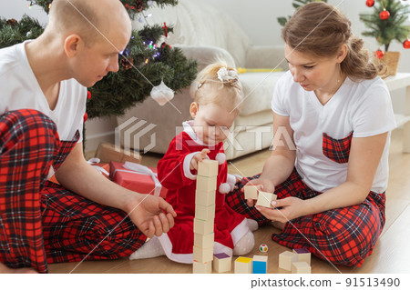 Baby child with hearing aid and cochlear implant having fun with parents in christmas room. Deaf , diversity and health and diversity Baby child with hearing aid and cochlear implant having fun with parents in christmas room. Deaf , diversity and health and diversity 91513490