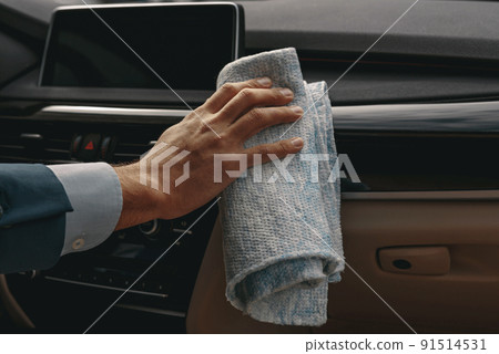 Man polishing dashboard and panel of car 91514531