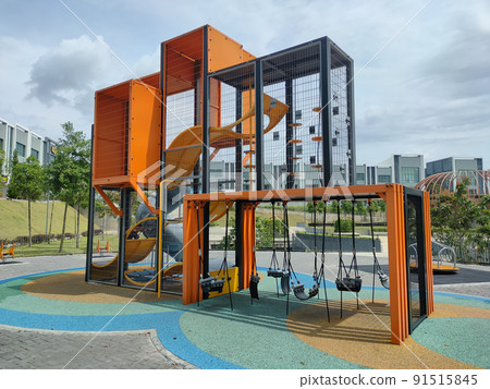 PENANG, MALAYSIA -MAY 8, 2022: Selected focused on modern children's outdoor playground in the public park. It was designed with a few different themes for kids to enjoy. Kids happy.  91515845