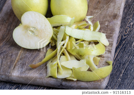 sliced and peeled green apple on a wooden board 91516313