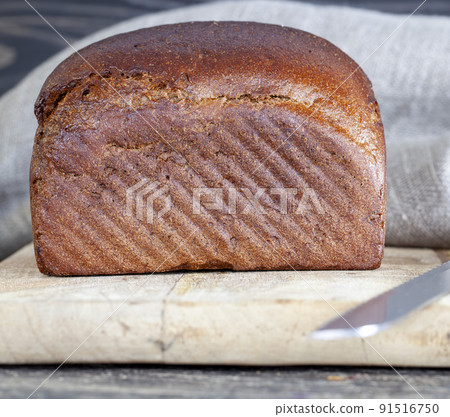 a square rye loaf of bread on a cutting board 91516750