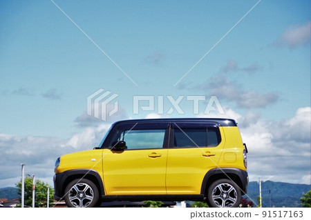 Blue sky and light car yellow Suzuki Hustler 91517163