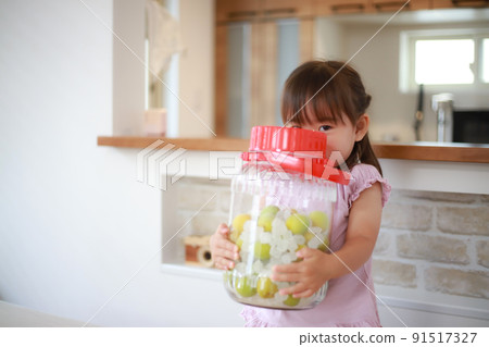 Girl with a bottle of plum syrup made 91517327