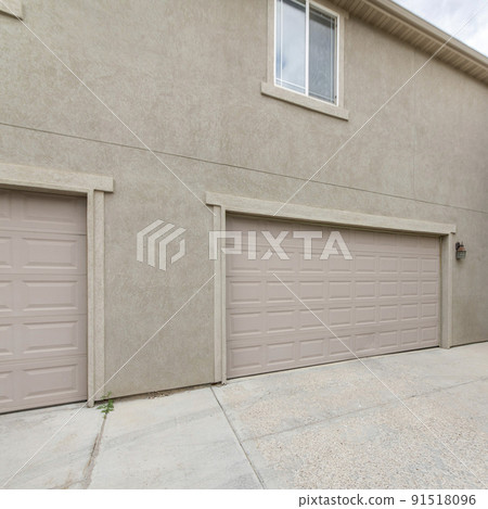 Square frame Exterior of two buildings with concrete driveway, garage doors and windows Square frame Exterior of two buildings with concrete driveway, garage doors and windows 91518096