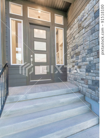 Vertical Home facade with stone brick wall and gray front door with frosted glass panels 91518100