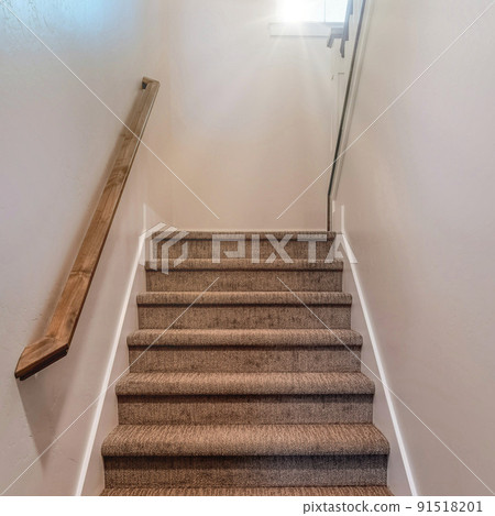 Square frame Stairway inside home with wall mounted wooden handrail and carpet on the treads Square frame Stairway inside home with wall mounted wooden handrail and carpet on the treads 91518201