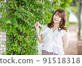 Green background: Young woman smiling looking at the camera 91518318
